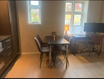 a kitchen with a table and chairs and a desk at Modern central apartment in a quiet area in Bergen