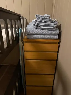 a stack of towels on a dresser next to a crib at Ski in-Ski out with Mountain View at Voss in Vossevangen
