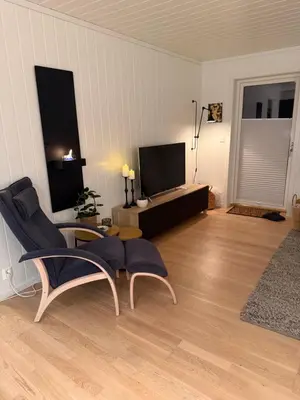 a living room with two chairs and a flat screen tv at Ski in-Ski out with Mountain View at Voss in Vossevangen