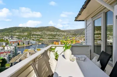 a balcony with a table and chairs and a view at Bright apartment with mountain views in Bergen
