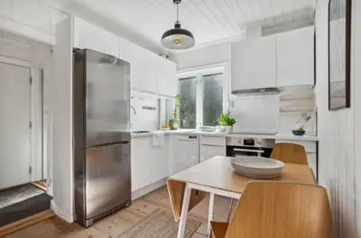 a kitchen with white cabinets and a stainless steel refrigerator at Bright apartment with mountain views in Bergen