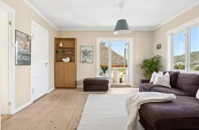 a living room with a couch and a table at Bright apartment with mountain views in Bergen