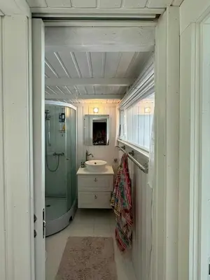 a small bathroom with a sink and a shower at Historic Cabin By The Atlantic Ocean Road in Vevang