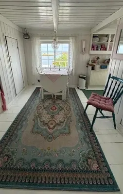 a room with a table and a chair and a rug at Historic Cabin By The Atlantic Ocean Road in Vevang
