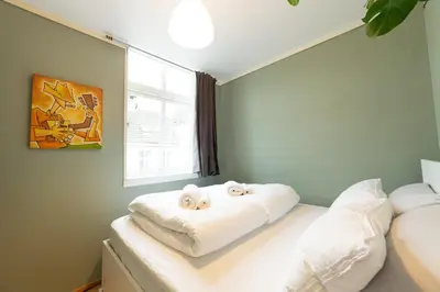 a bedroom with a bed with towels on it at Unique relaxed corner flat in central Bergen in Bergen