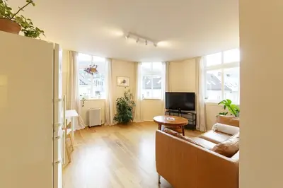 a living room with a couch and a tv at Unique relaxed corner flat in central Bergen in Bergen