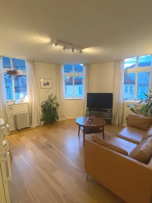 a living room with a couch and a table at Unique relaxed corner flat in central Bergen in Bergen