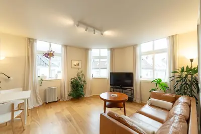 a living room with a couch and a tv at Unique relaxed corner flat in central Bergen in Bergen