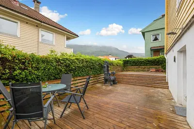 a patio with a table and chairs on a wooden deck at King bed - Free parking - Renovated June 2025 in Bergen