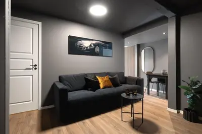 a living room with a black couch and a table at King bed - Free parking - Renovated June 2025 in Bergen