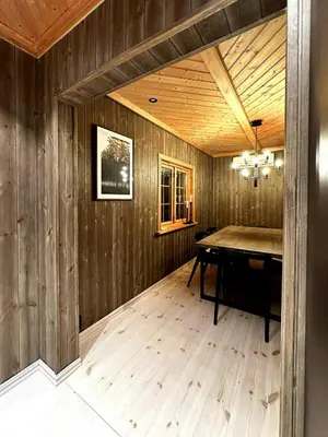 a dining room with a table and wooden walls at Nature-Close Cabin By Trysil Mountain in Trysil