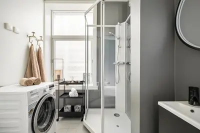 a bathroom with a washing machine and a shower at Bergen Beds Apartments - Unbeatable location! in Bergen