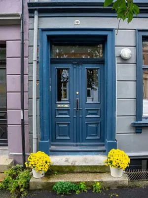 a blue door on a house with flowers in front at Authentic Bergen Apartment in Bergen