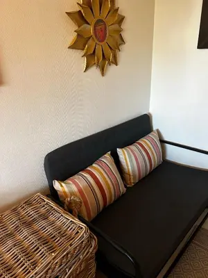 a black couch with a wicker table and a clock at Lade - Aqua Nor 2025 - inntil 7 personer in Lii