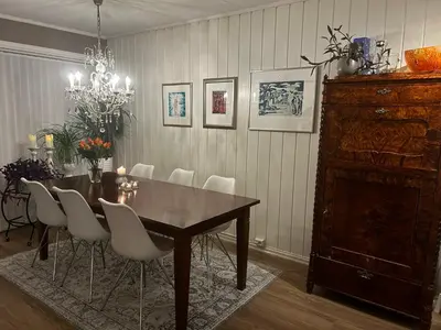 a dining room with a wooden table and white chairs at Lade - Aqua Nor 2025 - inntil 7 personer in Lii