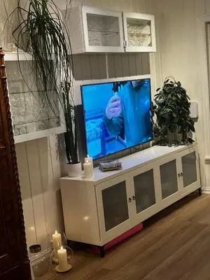 a flat screen tv sitting on top of a white cabinet at Lade - Aqua Nor 2025 - inntil 7 personer in Lii