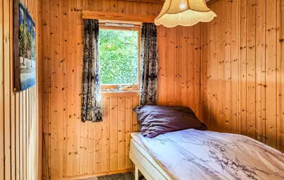 a bedroom with a bed in a wooden wall at Amazing Home In Frekhaug in Frekhaug
