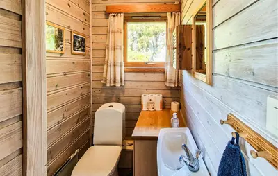 a bathroom with a sink and a toilet and a window at Amazing Home In Frekhaug in Frekhaug