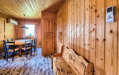 a dining room with a table and a wooden wall at Amazing Home In Frekhaug in Frekhaug