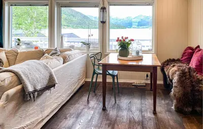a living room with a couch and a table at 3 Bedroom Amazing Home In Elnesvågen in Sylte