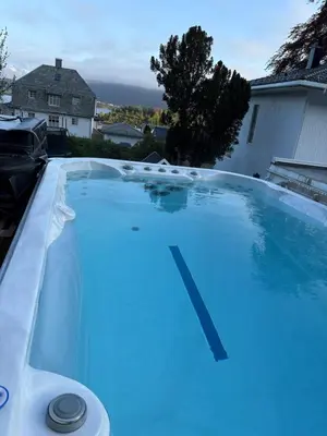 a swimming pool with blue water in a yard at Entire home with pool and garden in Ålesund