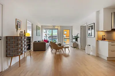 a kitchen and living room with a table and chairs at Roomsly Apartments - City flat with Private Balcony in Bergen