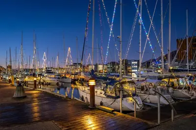 a group of boats docked in a marina at night at Roomsly Apartments - City flat with Private Balcony in Bergen