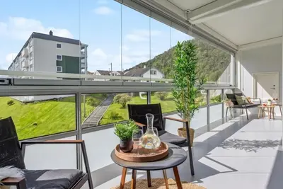 a balcony with a table and chairs and a large window at Downtown apartment with a view in Bergen