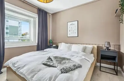 a bedroom with a white bed and a window at Downtown apartment with a view in Bergen