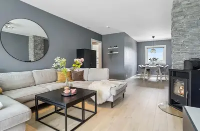 a living room with a couch and a table and a fireplace at Downtown apartment with a view in Bergen