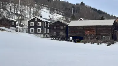 a group of buildings and a barn in the snow at Trivelig Stabbur på Lånke Gård