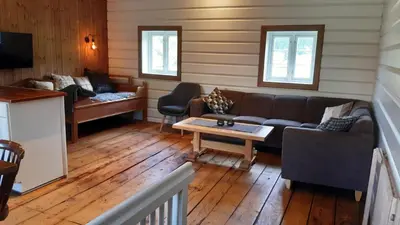 a living room with a couch and a table at Trivelig Stabbur på Lånke Gård