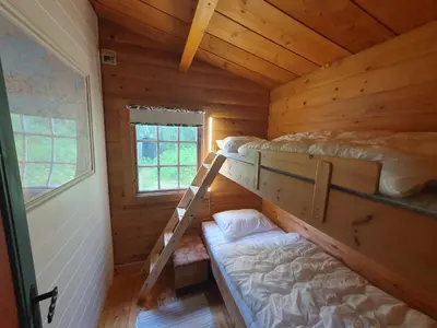 a room with two bunk beds in a log cabin at Feriehus Rodal med Båt in Rodal