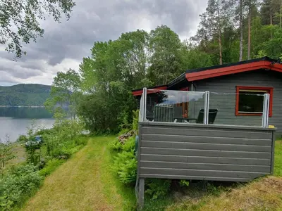 a cabin on the side of a lake at Feriehus Rodal med Båt in Rodal