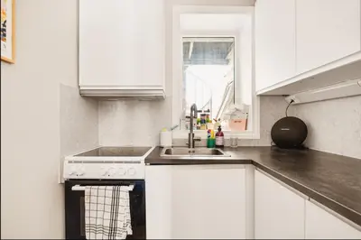 a white kitchen with a sink and a stove at Studio apartment centrally located in Bergen in Bergen