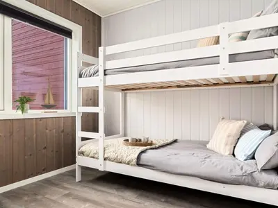 a bedroom with white bunk beds and a window at 8 person holiday home in Sandøy in Finnøy
