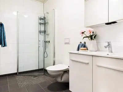 a white bathroom with a toilet and a shower at 8 person holiday home in Sandøy in Finnøy