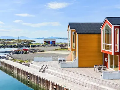 a house on the water with a dock at 8 person holiday home in Sandøy in Finnøy