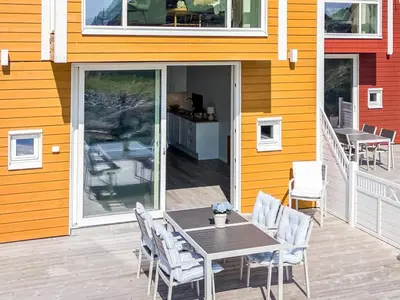 a patio with a table and chairs on a house at 8 person holiday home in Sandøy in Finnøy