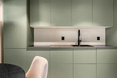 a kitchen with white cabinets and a sink at Trolltunga Fjord Stay in Odda