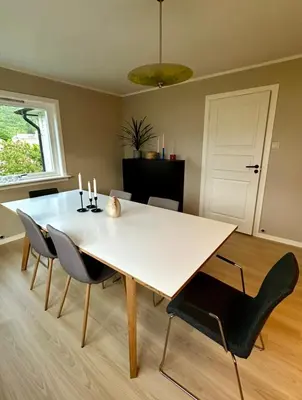 a dining room with a white table and chairs at Spacious holiday home by the fjord and mountains in Sæbø