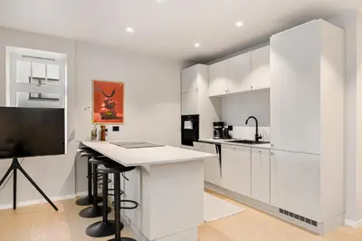 a kitchen with white cabinets and a counter top at Apartment in the heart of Ålesund city in Ålesund