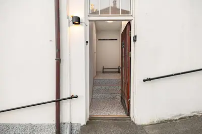 a hallway with stairs leading to a door at Apartment in the heart of Ålesund city in Ålesund