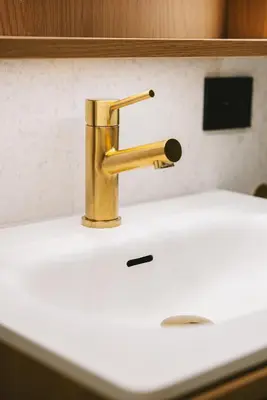 a bathroom sink with a gold faucet on it at Apartment in the heart of Ålesund city in Ålesund