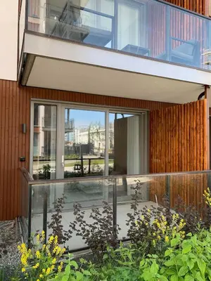 a glass house with a balcony and a garden at New and modern apartment in Trondheim, Øvre Nyhavna in Trondheim