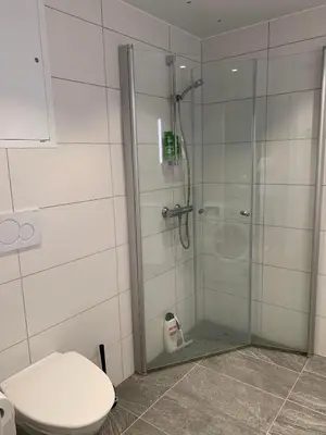 a bathroom with a glass shower with a toilet at New and modern apartment in Trondheim, Øvre Nyhavna in Trondheim