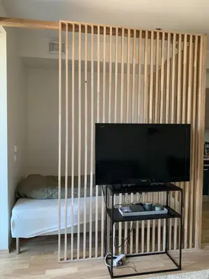 a room with a crib with a tv and a bed at New and modern apartment in Trondheim, Øvre Nyhavna in Trondheim