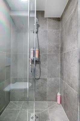 a shower with a glass door in a bathroom at Central stay apartment - 201 in Bergen
