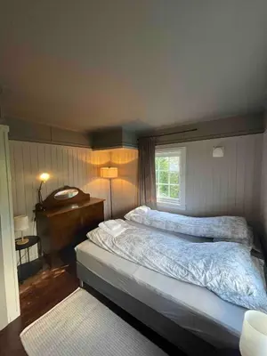 a bedroom with a large bed and a piano at Traditional Norwegian Villa, Bay view and boat in Bergen
