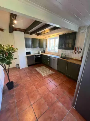 a large kitchen with green cabinets and a tile floor at Traditional Norwegian Villa, Bay view and boat in Bergen
